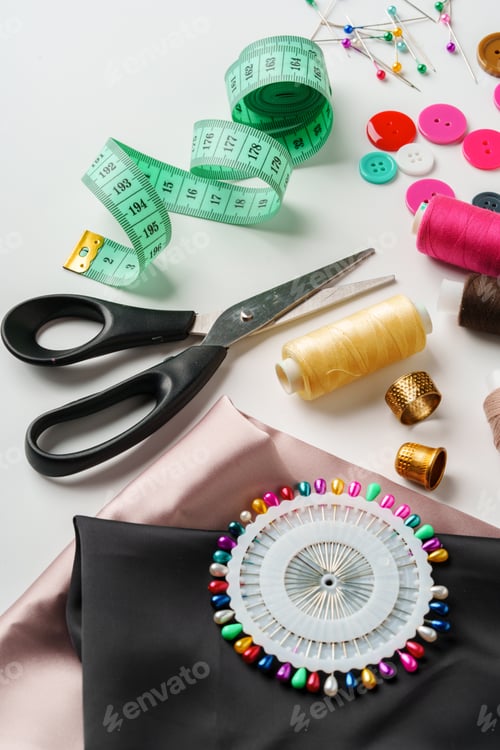 Preview: Crafting essentials for sewing projects displayed on a table with fabric, threads, and tools