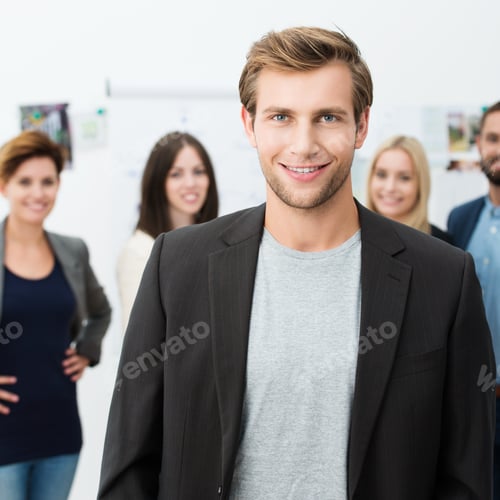 Preview: Confident Smiling Unshaven Young Businessman Looking At The Camera With A Friendly Smile With His