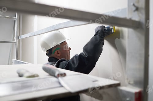 Construction Worker Smoothing Wall Wearing Safety Gear