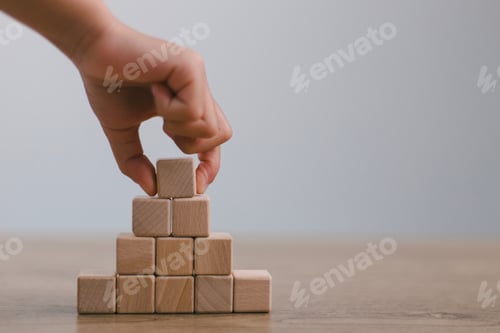 Preview: Businesswomen stack blank wooden cubes on the table with copy space,