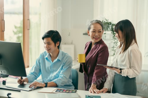 Preview: Group of asian designer talking and development ux app on mobile phone during the meeting in office.