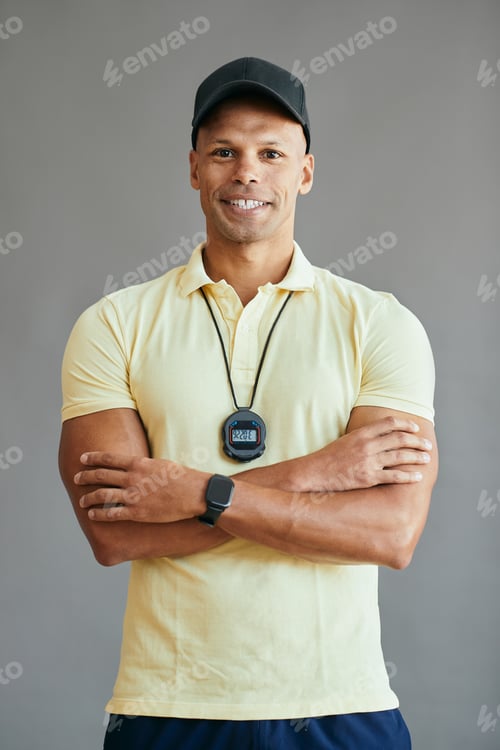 Preview: Happy personal trainer standing with arms crossed and looking at camera