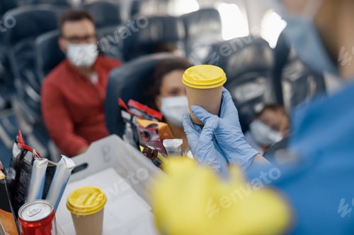 Preview: Close up shot of hands in protective gloves of flight attendant serving drinks