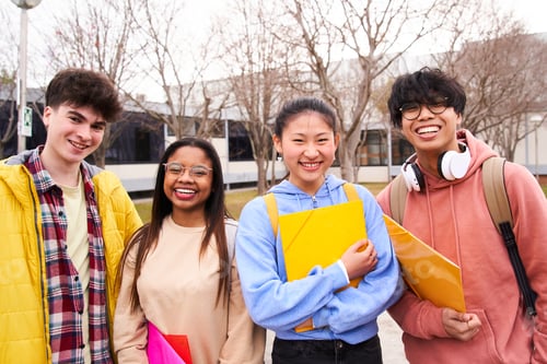 Preview: Portrait of a group of four students standing up and looking at camera.