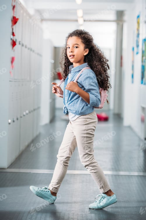 Preview: beautiful african american girl walking through school corridor