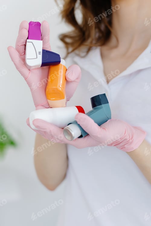 Preview: Female doctor holding and showing asthma inhaler. Medical portable equipment for asthma attack