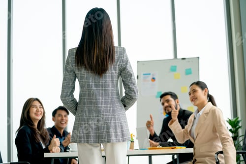 Preview: Back of business woman talk about the project in front of her coworkers and they look happy