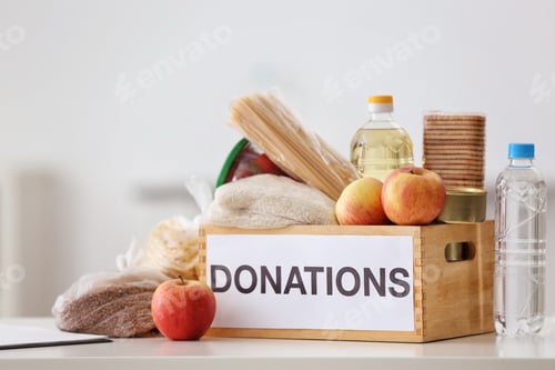 Preview: Donation box with food products on table indoors