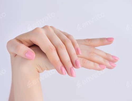 Preview: Closeup of hands of a young woman with pink manicure on nails ag