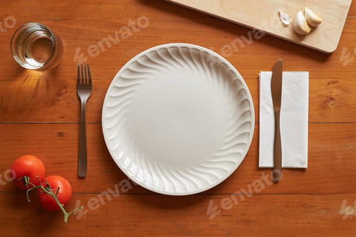 Preview: Porcelain plate and cutlery against a wood background with mediterranean elements