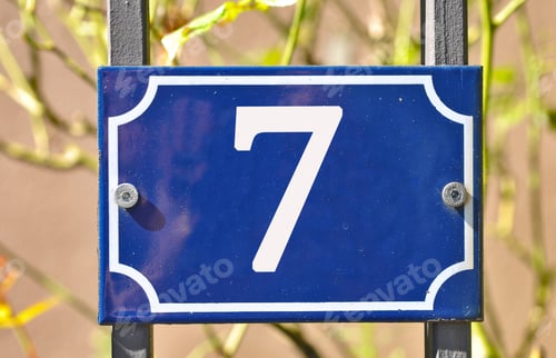 Preview: Closeup shot of a blue sign with the number 7 on the blurry background