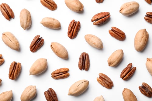 Preview: Composition with pecan nuts on white background, top view