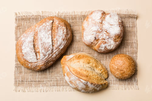 Preview: Assortment of freshly baked bread with napkin on rustic table top view.