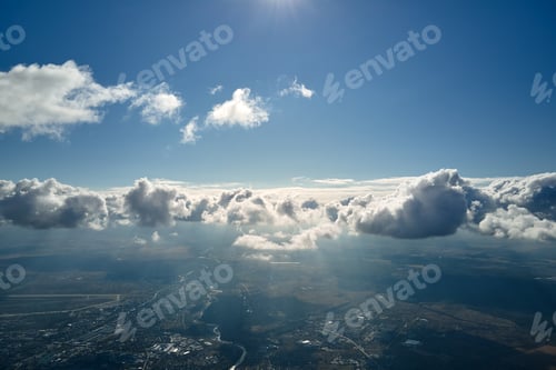Preview: Aerial view from airplane window at high altitude of earth covered with white puffy cumulus clouds