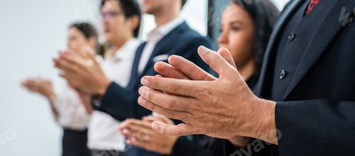Preview: Close up hand of young businessman and businesswoman clapping together.