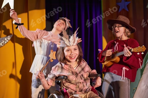 Preview: Happy Young Girl in Wheelchair Acting out Magician on Stage at Drama School