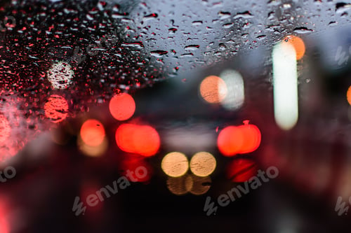 Preview: Abstact and bokeh background. Rain drops on car window in rainy season. raining car driving concept.