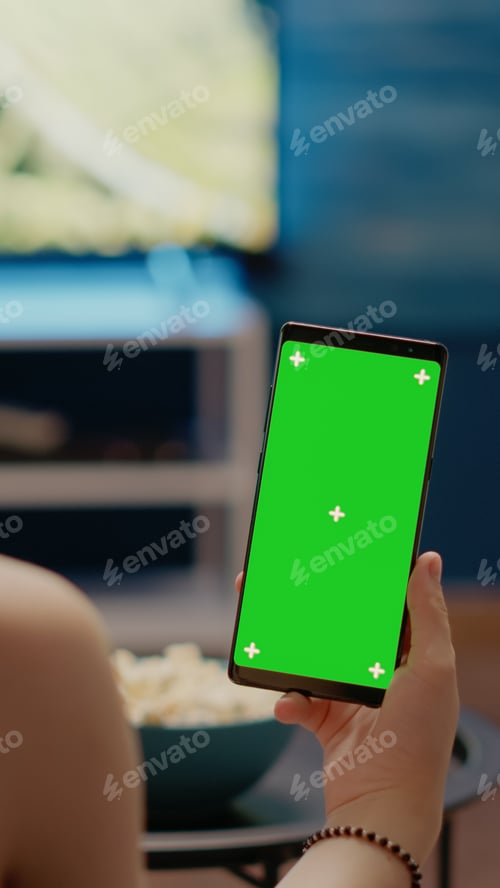 Preview: Young person with vertical green screen display on smartphone
