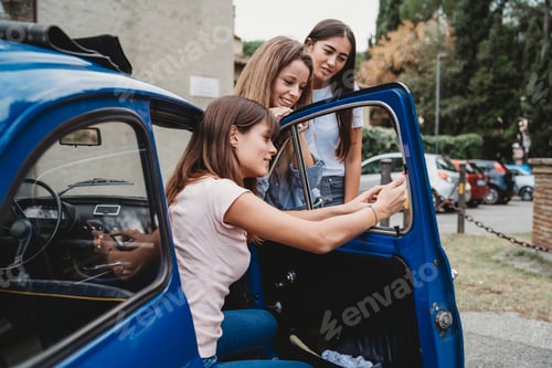 Preview: Friends using smartphone beside car
