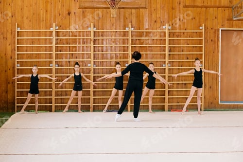 Preview: Group of Preteen Caucasian Girls Practicing Gymnastics with Female Coach
