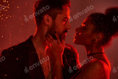 Preview: Intimate moment shared by a passionate couple under captivating red lights in a velvety embrace