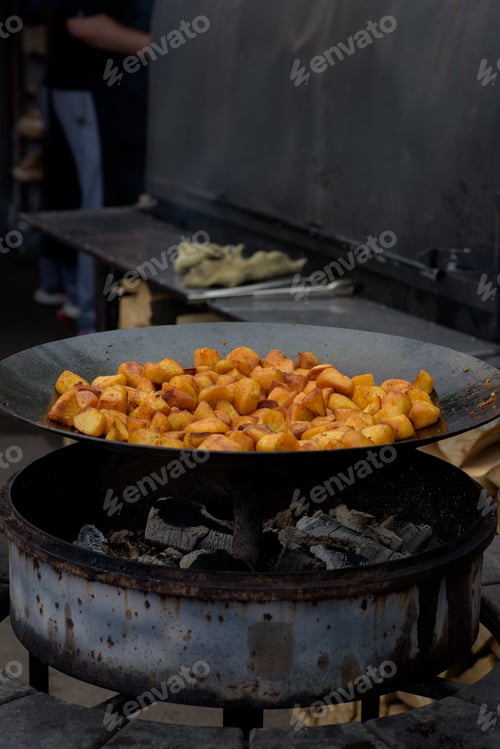 Preview: Chunks of fried potatoes in a large skillet during the street food festival.