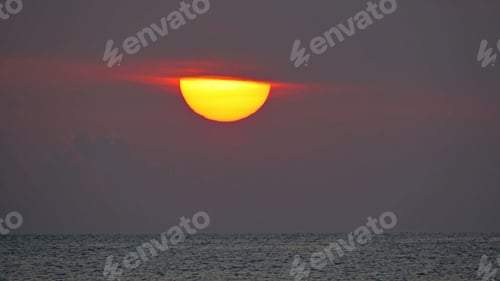 Preview: Stunningly serene ocean sunset. The sun hidden behind clouds.
