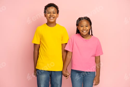 Preview: African American kids, brother and sister wearing pink and yellow t shirts holding hands. Friendship