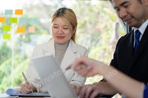 Preview: Diverse business team collaborating on analysis and discussion in a modern workspace.