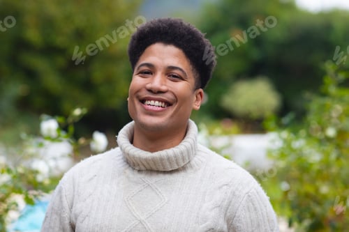 Preview: Portrait of happy biracial man smiling to camera in garden