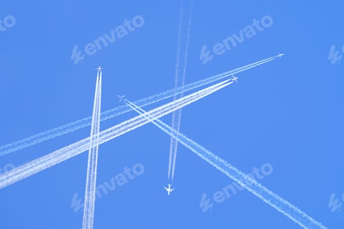 Preview: Many distant passenger jet planes flying on high altitude on clear blue sky leaving white smoke