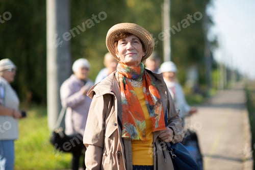 Preview: Portrait of smiling senior woman wearing summer hat traveling on during covid-19 pandemic