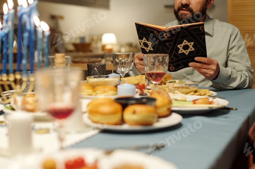 Preview: Focus on cropped mature man reading Torah in black cover with star of David