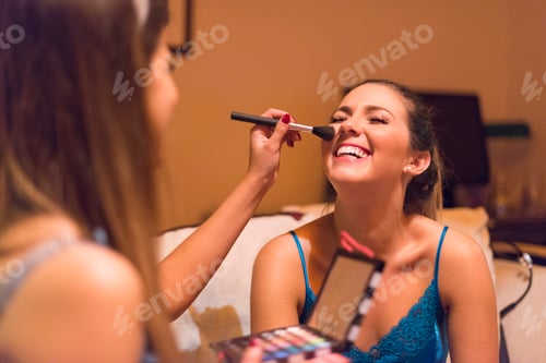Preview: Two young women, applying make-up