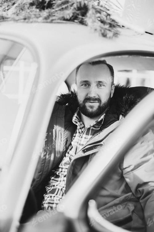 Preview: Beautiful strong Caucasian man sits in his car