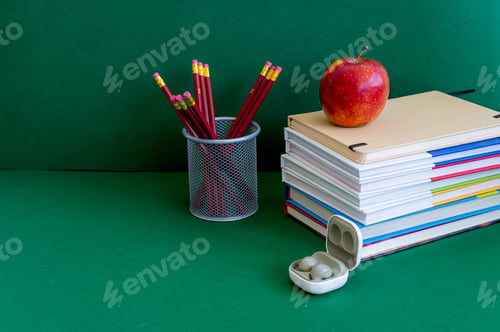 Preview: Colorful school supplies on a green background