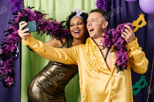 Preview: Cheerful friends having fun and taking selfie on Mardi Gras party.