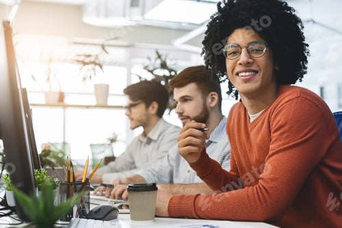 Preview: Cheerful african american guy smiling at camera at coworking