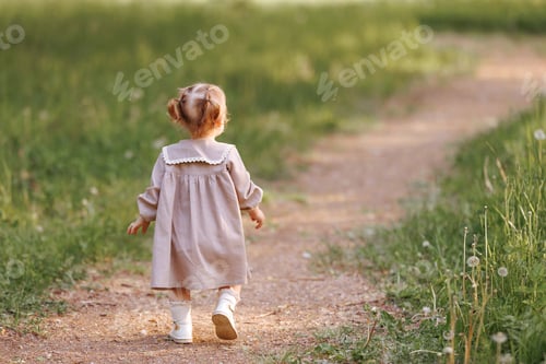 Preview: Small child girl walking in the park.