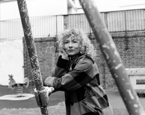 Preview: Analogue portrait of confident woman leaning on swing structure.