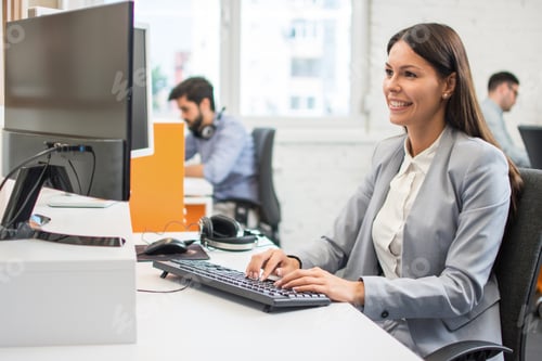 Preview: Smiling businesswoman using computer in office
