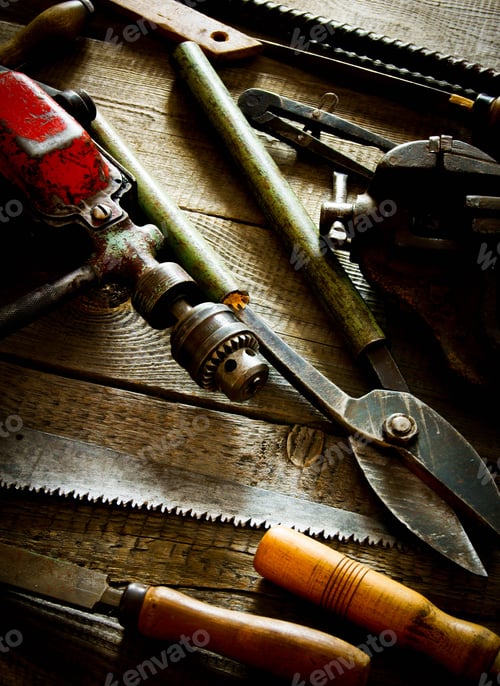 Preview: Many old working tools (drill, saw, chisel and others) on a wooden background.