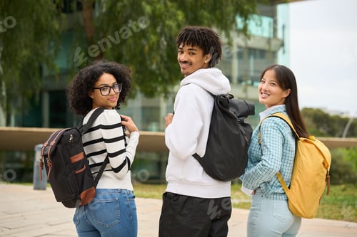 Preview: Three young students are standing together, each carrying a backpack