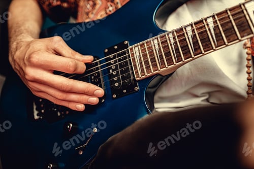 Preview: Close up of male hand playing electric guitar in the dark