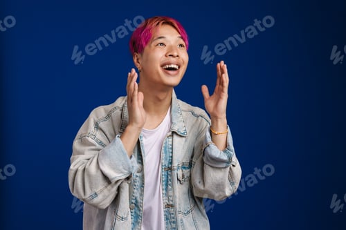 Preview: Asian boy with pink hair expressing surprise at camera