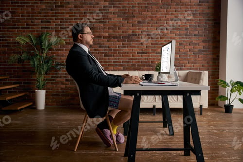 Preview: Funny geek businessman wearing formal suit and soft home slippers working online