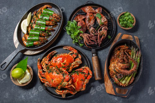 Preview: Set of Seafood Dishes. Crabs, octopus, squids and tiger shrimps on cast iron pans and plates on a