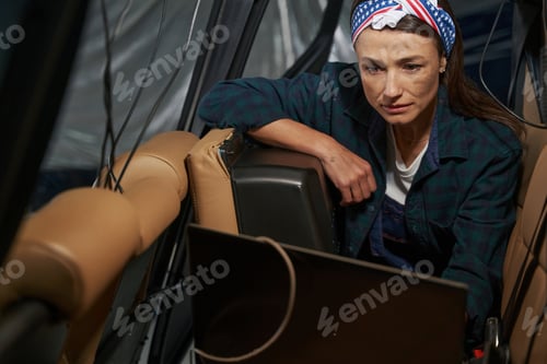 Preview: Charming woman engineer testing jet engine with computer in copter salon