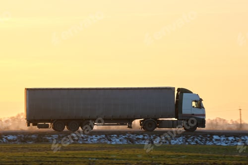 Preview: Semi-truck with cargo trailer driving on highway hauling goods in evening