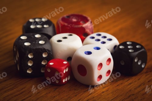 Preview: different size and color rolling dices on wooden background